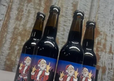 Flaskor med julmust från Bryggeri Viktoria med tomte-etikett uppställda i butiken.
