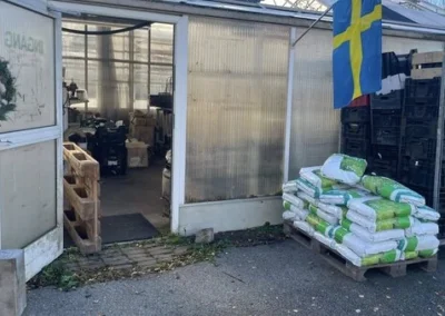 Entrén till loppisen butik i Gudhem med svensk flagga och säckar utanför.
