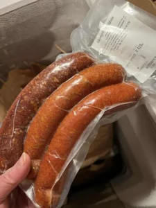 Vakuumförpackad Askumgrillare vildsvinskorv med tre varmrökta grillkorvar och tydlig innehållsetikett, säljs fryst.